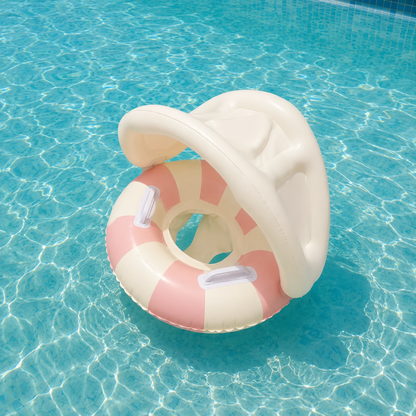 Gros plan d'une bouée bébé gonflable avec pare-soleil aux tons rose pastel