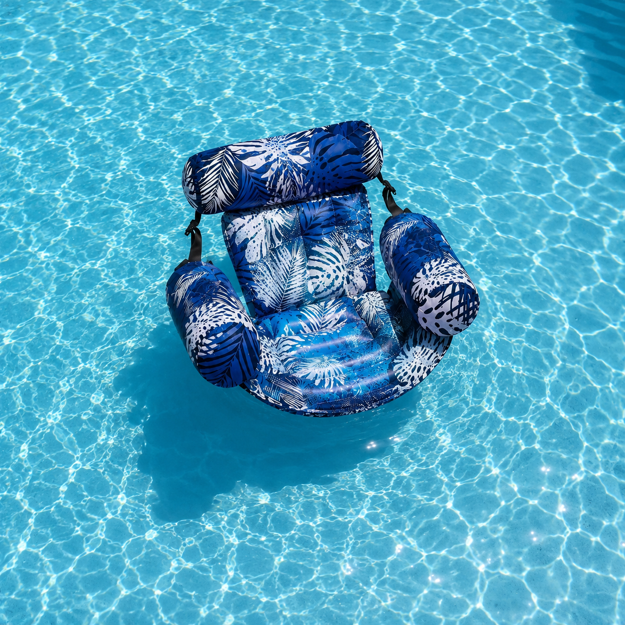 Fauteuil aquatique gonflable bleu motif feuilles flottant dans une piscine