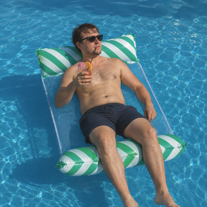 Homme se détendant sur un hamac de piscine gonflable motif feuilles vertes