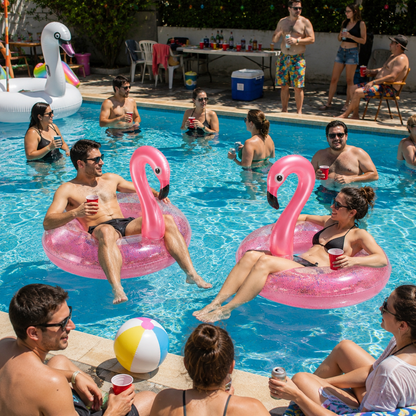Groupe profitant de bouées flamant rose gonflables à la piscine